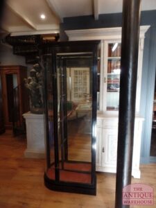 Antieke zwarte vitrinekast met rode bodem en gebogen glazen