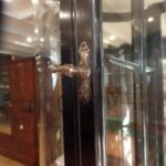 Antieke zwarte vitrinekast met rode bodem en gebogen glazen 3